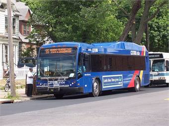 Bus pulling up to bus stop and loading passengers