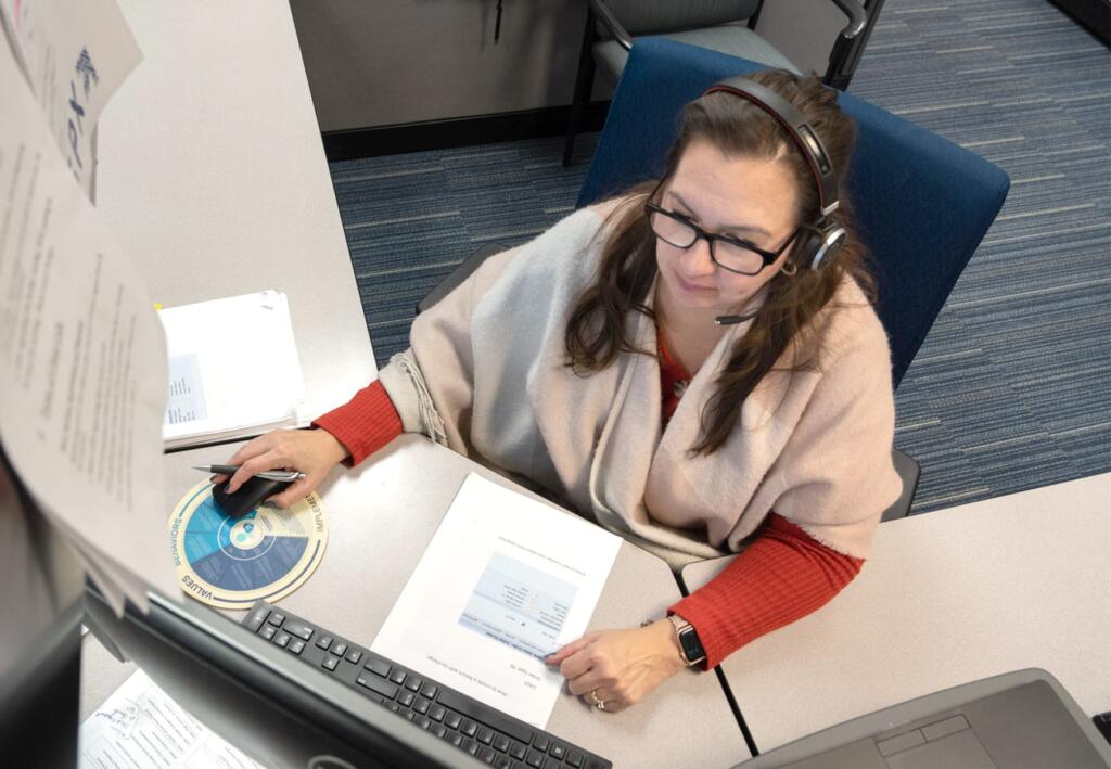 Genfare Customer Care representative on the phone and typing on the computer