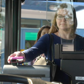 Person pays bus fare with contactless payment