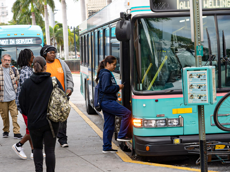 people boarding a Palm Tran bus at a bus stop